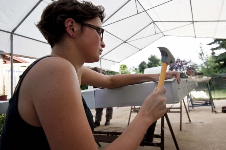 Theresa befestigt mit einem Hammer die Wand der Komposttoilette. | Foto: Hendrik Silbermann (ARTWORKs)